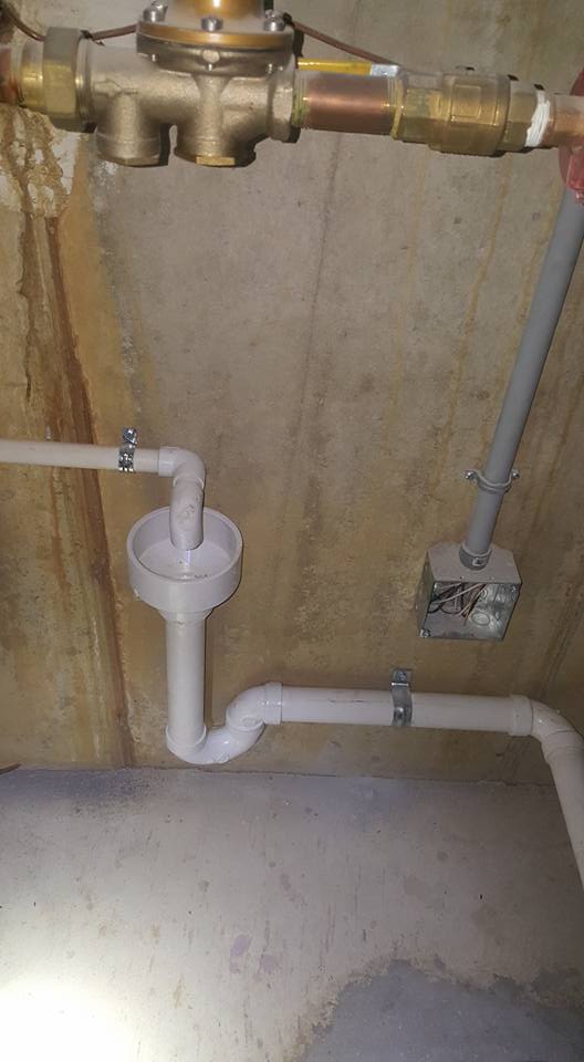 New PVC drain piping on a basement wall