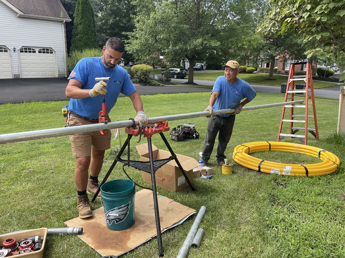 Plumbers repairing a gas line in a yard